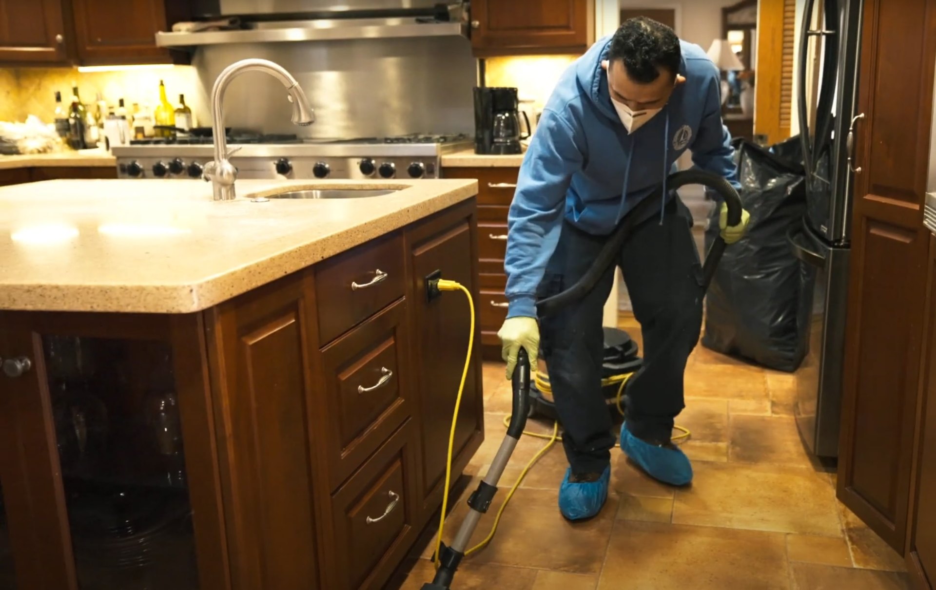 Expert water damage restoration in progress Professional water damage restoration technician using specialized equipment in residential kitchen