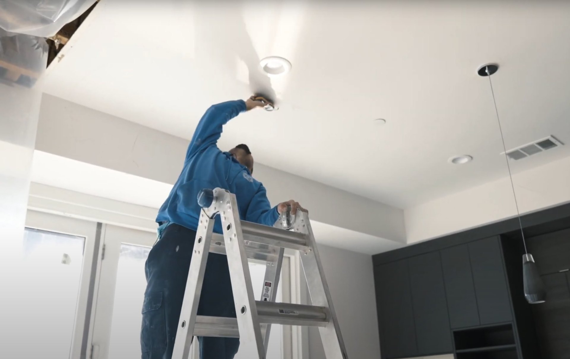 Professional ceiling water damage restoration Water damage restoration specialist performing ceiling repairs with professional equipment